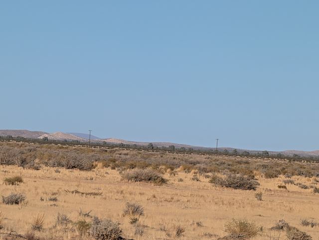 Open desert plain with power lines along the far edge.
