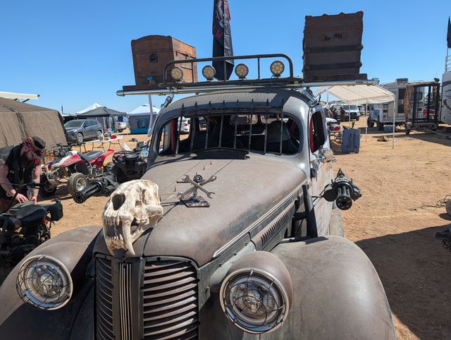The war car's chrome grille and headlights crowned with a fanged skull.