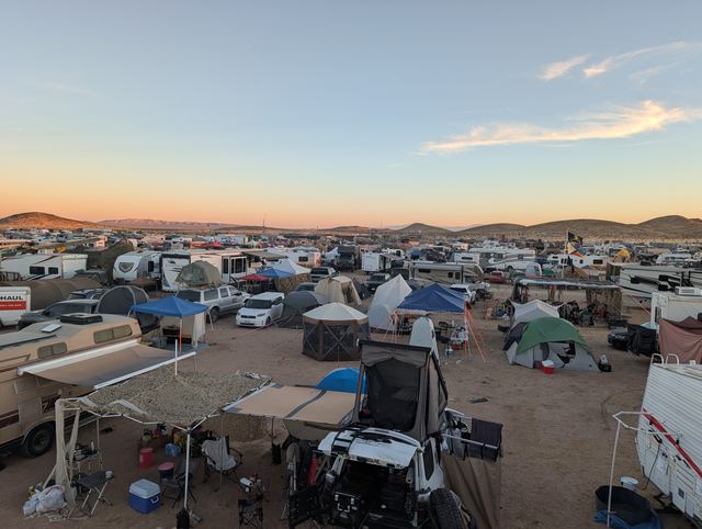 Panorama over the tribe camp's canopies with thin clouds above.