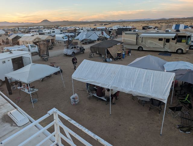 Morning over the campground seen from an RV roof, white canopies below.