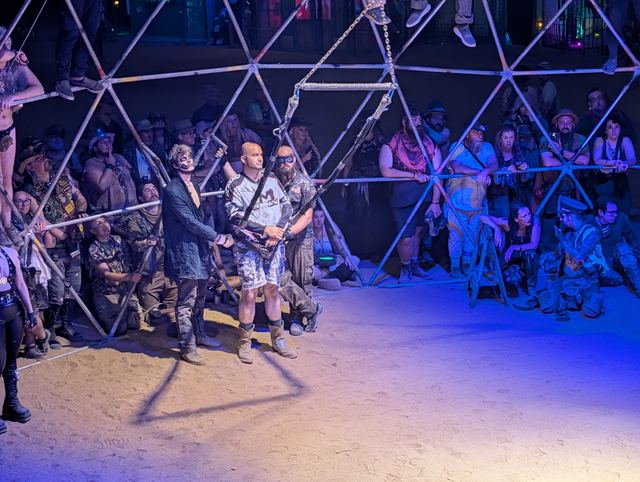 Fighters circle each other in the dome while the crowd watches from the bars.