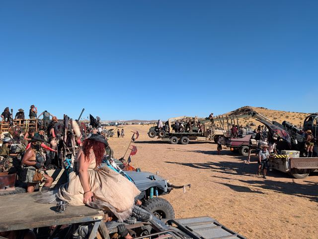 War rigs lined up across the flats, wastelanders climbing onto the vehicles.
