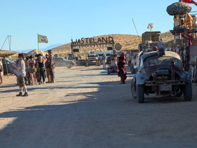 War rigs and walkers crowd the road near the Wasteland gate.