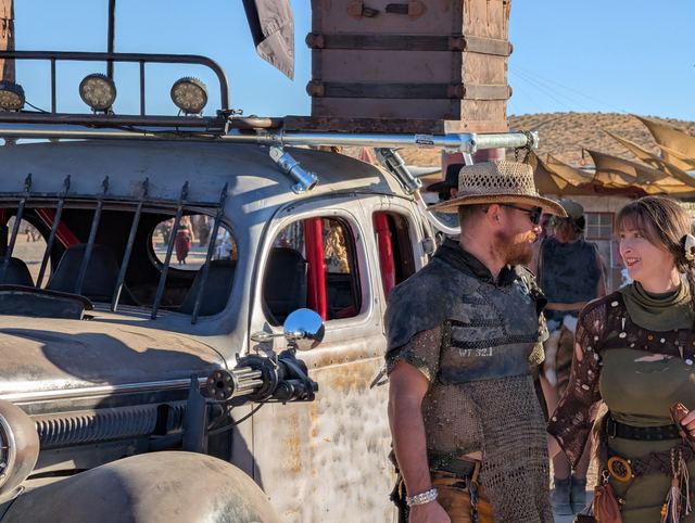 The chainmail couple by the war car's barred windows.